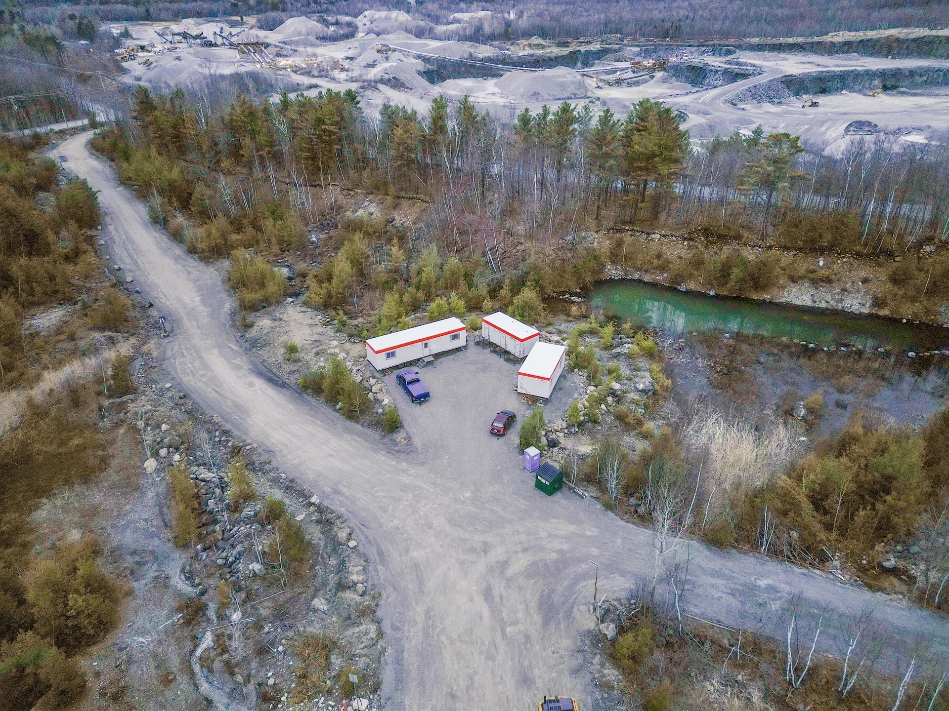 Vue aérienne de roulottes de chantier installées près d’une carrière, offrant des espaces temporaires pour gérer les travaux sur le terrain.